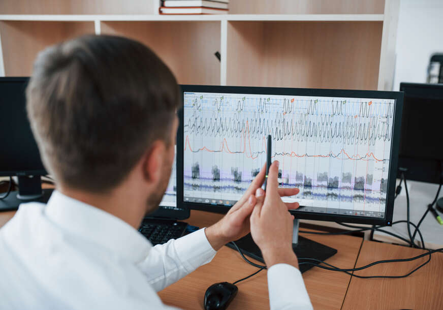 Working process. Polygraph examiner in the office with his lie detector's equipment
